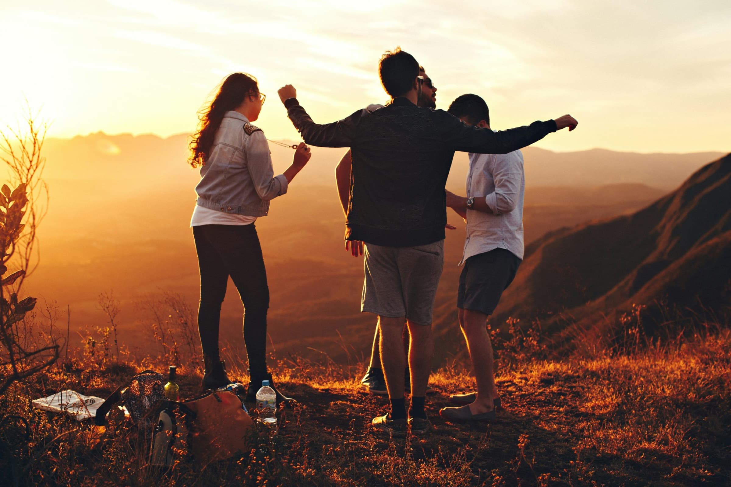 Friends on a hillside at sunset